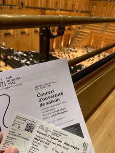 An image of the concert programs in front of the seats in the concert hall. The text reads "Concert d'ouverature de saison" which translates to the opening concert of the season.