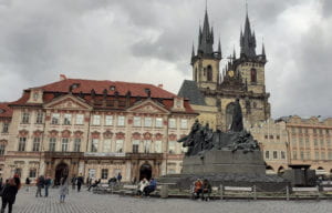 One end of the Old Town Square, with prime examples of Prague Baroque architecture, the Jan Hus Memorial, and the turreted Gothic towers of the Church of Mother of God before Týn in the background.